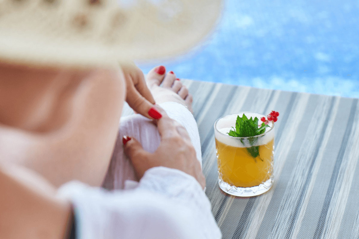 ragazza con cocktail alla frutta a bordo piscina