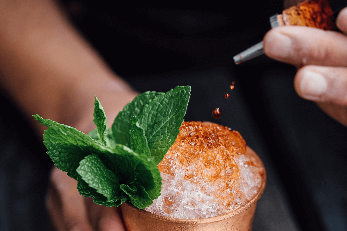 Barman aggiunge del bitter a un cocktail