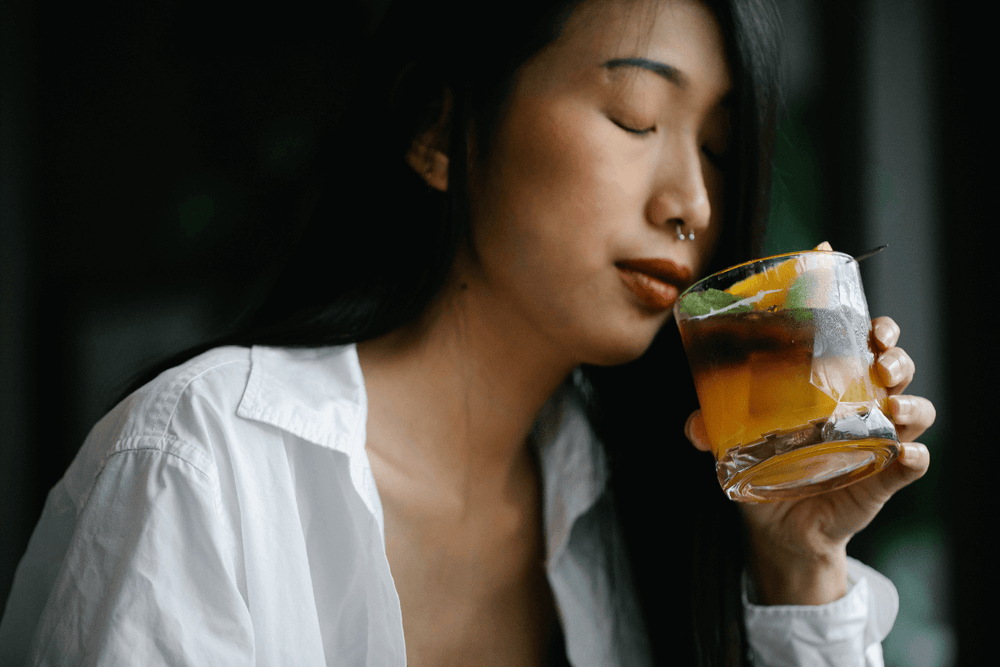 Ragazza asiatica che beve un cocktail autunnale